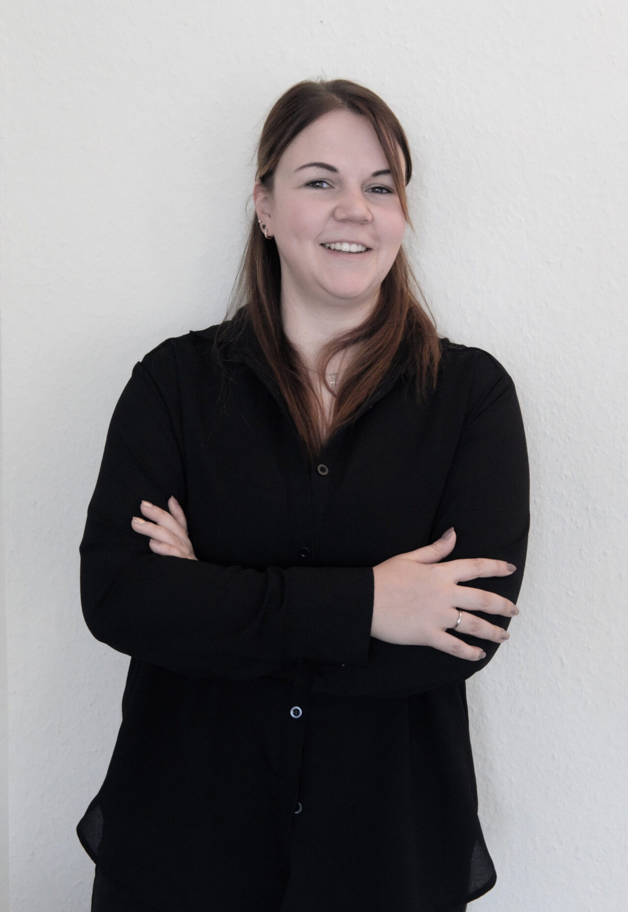 Frau in schwarzem Hemd, verschränkte Arme.