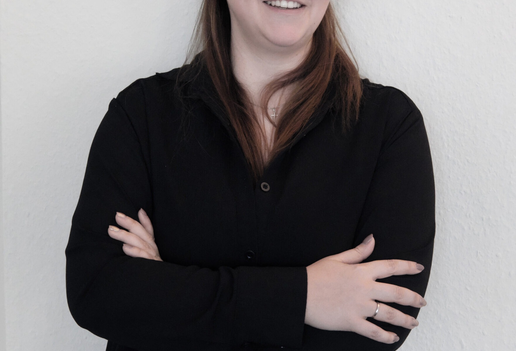 Frau in schwarzem Hemd, verschränkte Arme.